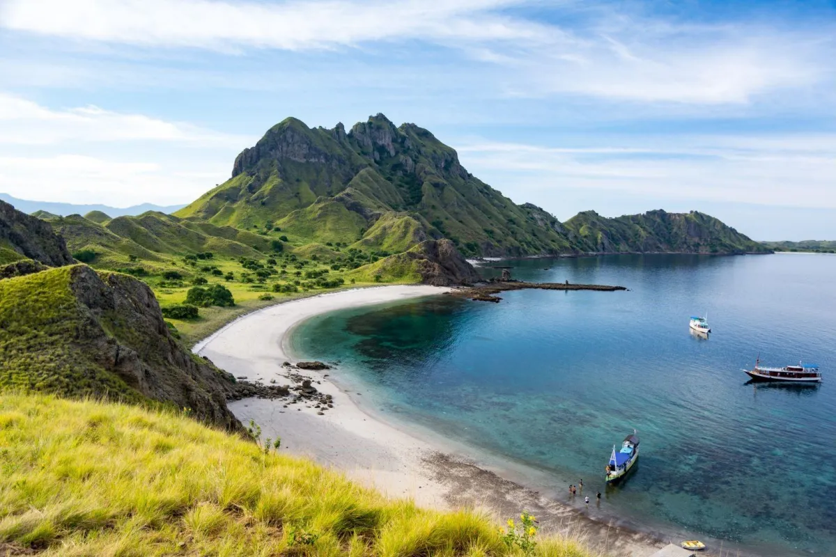 Panoramic beach view of Komodo Island with green hills behind